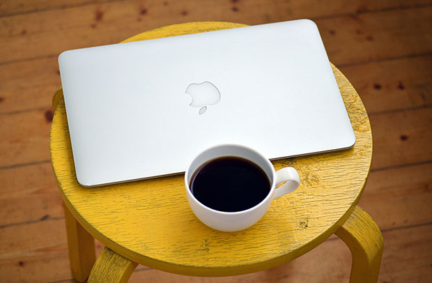 Macbook, xícara, café e banquinho
