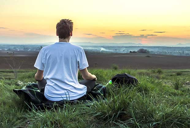 Homem meditando no campo - Decisões são Influenciadas pela Emoção - Rebeca Toyama